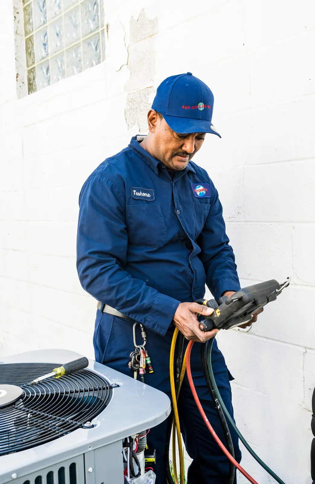 Technician reading refrigerant gauges